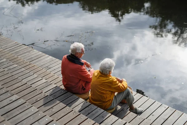 Szczęśliwa Para Seniorów Jesiennym Spacerze Nad Jeziorem Mając Przerwę Siedząc — Zdjęcie stockowe