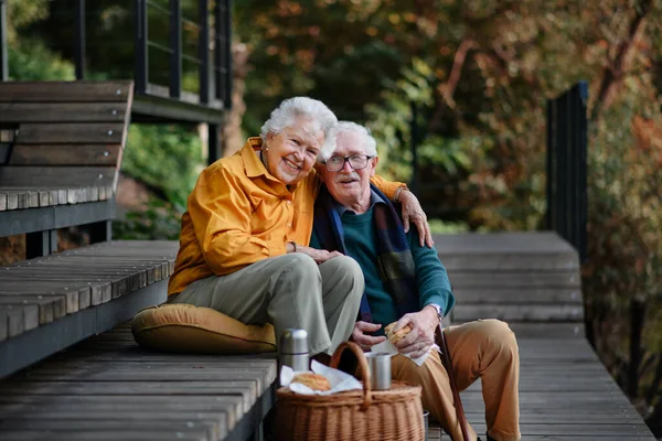 Šťastný Starší Pár Odpočívá Blízkosti Jezera Procházce Při Pohledu Smartphone — Stock fotografie