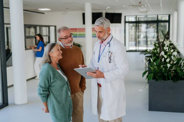 Hastane Koridorunda Kıdemli Hastalarıyla Konuşan Olgun Bir Doktor — Stok fotoğraf