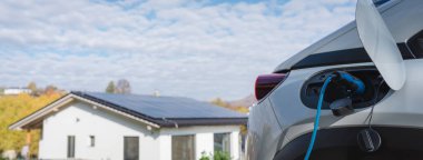 Evde şarj aleti olan elektrikli araba, sürdürülebilir ulaşım konsepti..