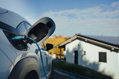 Evde şarj aleti olan elektrikli araba, sürdürülebilir ulaşım konsepti..