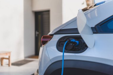 Evde şarj aleti olan elektrikli araba, sürdürülebilir ulaşım konsepti..