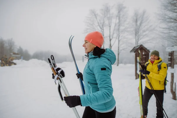 冬の森をスキーで横断するシニアカップル — ストック写真
