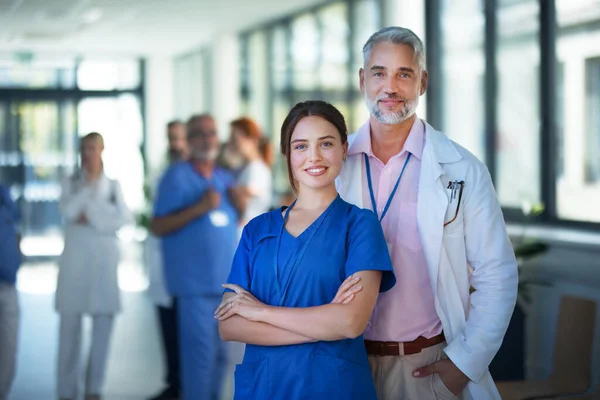 Porträtt Ung Kvinnlig Läkare Med Sin Äldre Kollega Sjukhuskorridor — Stockfoto