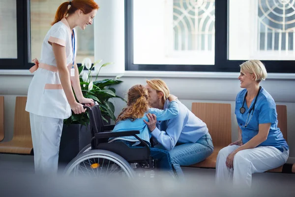 坐在轮椅上和母亲在医院打招呼的小女孩 — 图库照片