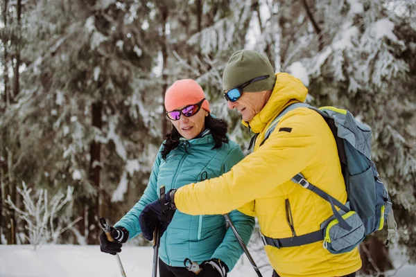 冬のスキー中にスマートウォッチをチェックするシニアカップル — ストック写真