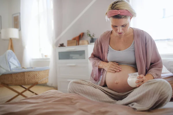 Zwangere Vrouw Crèmeert Haar Buik Zit Een Bed Zorgt Voor — Stockfoto