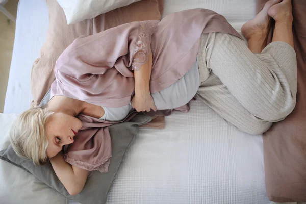 妊娠中の女性の寝ているとベッドの中で休んでのトップビュー — ストック写真