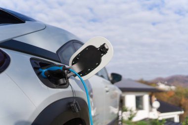 Evde şarj aleti olan elektrikli araba, sürdürülebilir ulaşım konsepti..