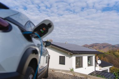 Evde şarj aleti olan elektrikli araba, sürdürülebilir ulaşım konsepti..