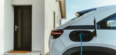 Evde şarj aleti olan elektrikli araba, sürdürülebilir ulaşım konsepti..