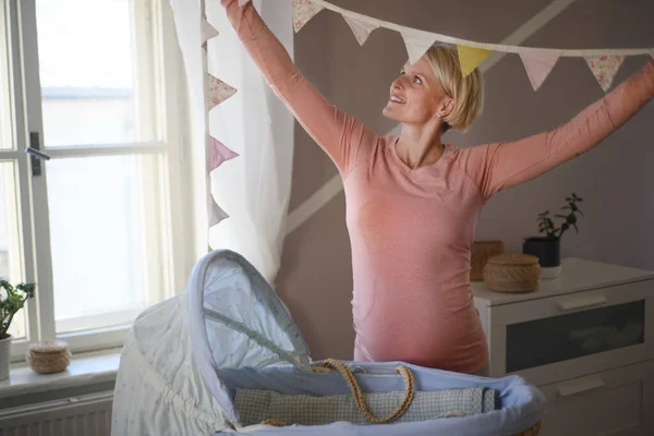 妊娠中の女性は赤ちゃんのための部屋を準備 — ストック写真