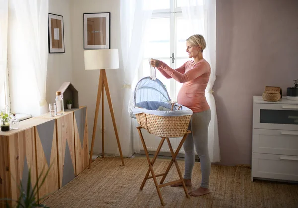 Glücklich Schwangere Frau Schaut Auf Kleine Babykleidung — Stockfoto