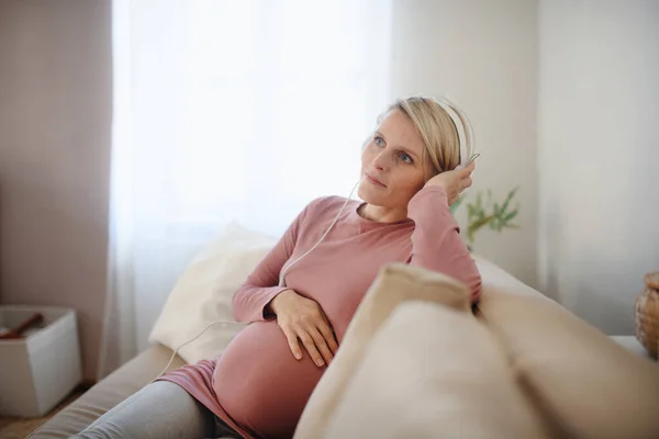 Έγκυος Γυναίκα Κάθεται Έναν Καναπέ Ακούγοντας Μουσική Και Απολαμβάνοντας Χρόνο — Φωτογραφία Αρχείου