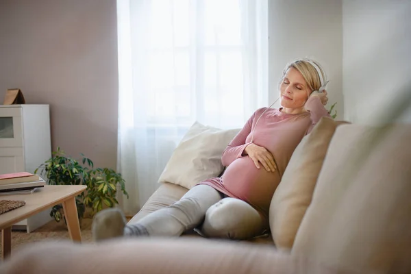 Έγκυος Γυναίκα Κάθεται Ένα Κρεβάτι Ακούγοντας Μουσική Και Απολαμβάνοντας Χρόνο — Φωτογραφία Αρχείου