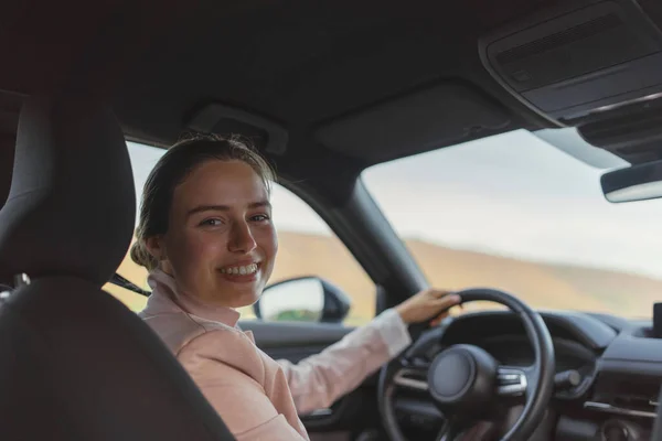 stock image Rear view of young woman driving electric car.