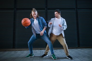Down sendromlu bir adam arkadaşıyla dışarıda basketbol oynuyor. Topluma engelli insanlarla arkadaşlık ve bütünleşme kavramı.