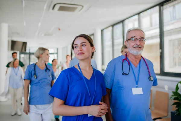 Yaşlı Doktor Genç Meslektaşının Portresi Hastane Koridorunda Sağlık Hizmeti Kavramı — Stok fotoğraf