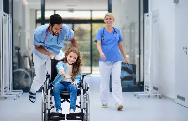 Young Doctor Pushing Little Girl Wheelchair Pediatric Corridor Having Fun — Stock Photo, Image