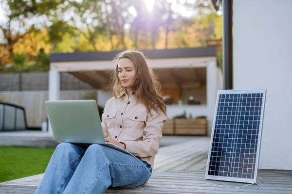 Młoda Kobieta Siedzi Tarasie Ładując Tablet Przez Panel Słoneczny — Zdjęcie stockowe