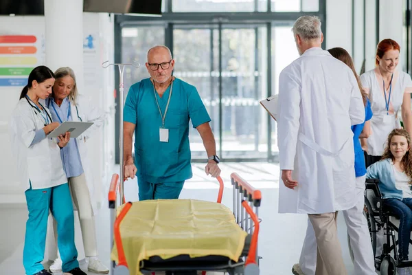 Caregiver Pushing Hospital Bed Corridor His Colleagues Taking Care Patients — Stockfoto