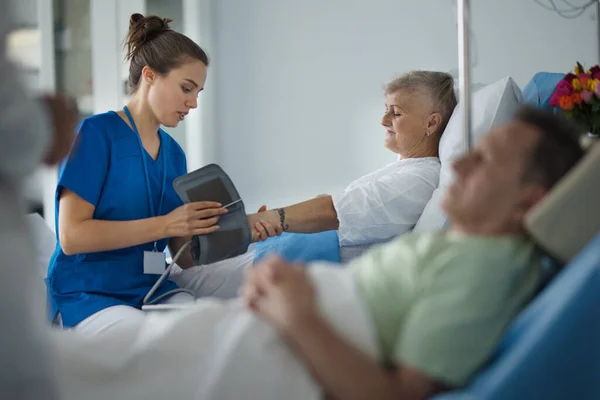 Ung Sjuksköterska Mäter Blodtryck Till Seniorpatient — Stockfoto