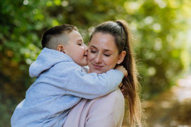 Portrait of mother with her son in a forest.