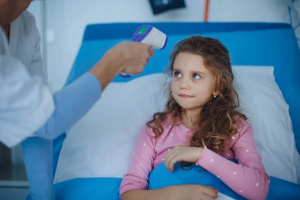 Медсестра Измеряет Температуру Тела Маленькой Девочки Лежащей Больнице — стоковое фото