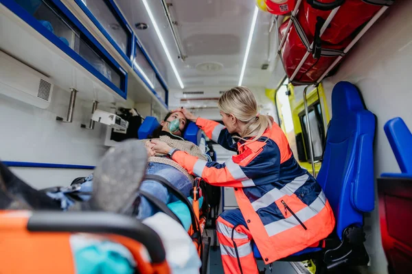Rescuer taking care of a patient, preparing her for transport.