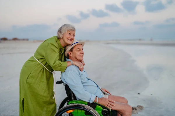 車椅子の老人は海で妻と一緒に時間を楽しむ — ストック写真