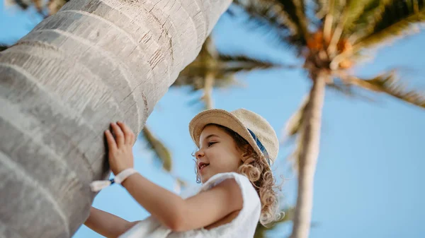 Szczęśliwa Dziewczynka Przytula Palmę Podczas Tropikalnych Wakacji — Zdjęcie stockowe