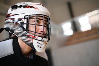 Kask takmış kadın langırt kalecisinin yakın plan çekimi. Spor salonunda maç izleyeceğiz..