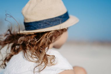 Side view of little girl looking at the ocean.