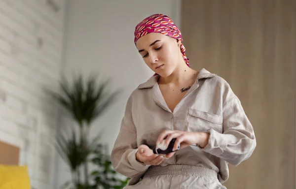 Young woman with cancer taking the pills, cancer awareness concept.