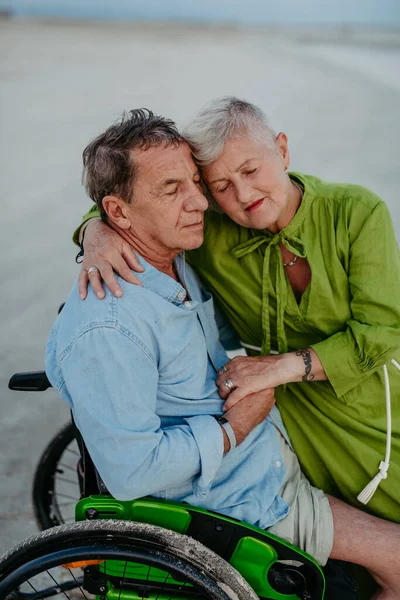 車椅子の老人は海で妻と一緒に時間を楽しむ — ストック写真