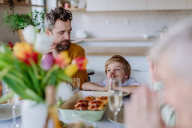 Close-up of family praying before Easter dinner.