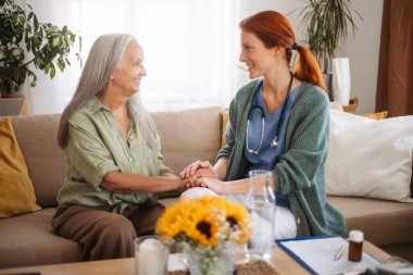 Portrait of caregiver holding hand to senior client.