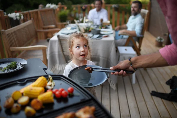 Ojciec Kładący Grillowane Mięso Warzywa Talerzu Swojej Córce Podczas Rodzinnej — Zdjęcie stockowe
