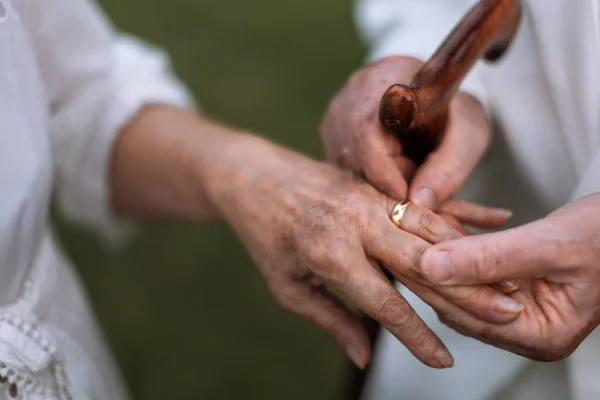Close Van Senioren Handen Met Gouden Trouwringen Tijdens Hun Huwelijk — Stockfoto