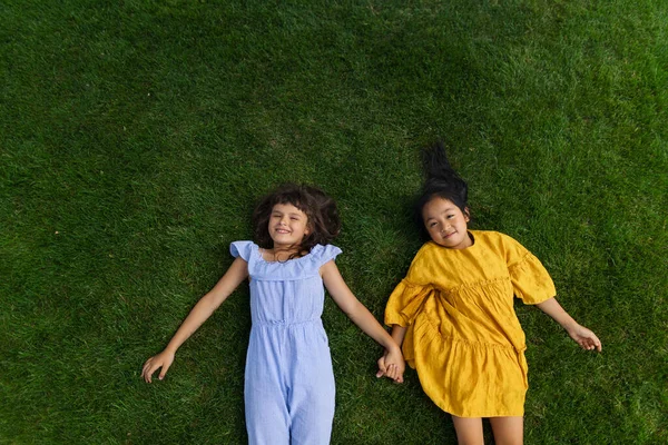 Happy Four Friends Lying Grass Holding Each Other Hands Having — Fotografia de Stock