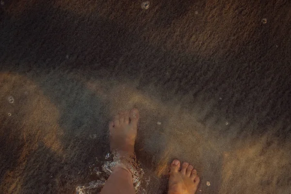 日没時にビーチを歩く女性 足のクローズアップ — ストック写真