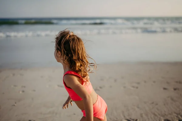穿着泳衣的小女孩在海滩上跑步 享受暑假 — 图库照片