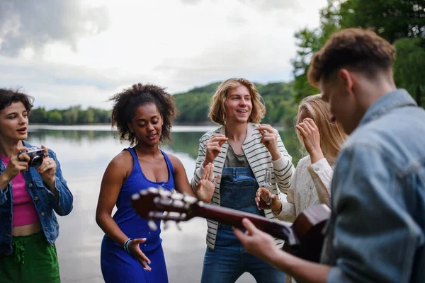 Group Young Friends Having Fun Lake Laughing Playing Guitar — Φωτογραφία Αρχείου