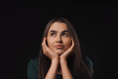Stüdyoda genç bir kadının portresi, siyah arka plan.