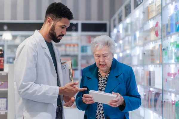 Junge Apothekerin Hilft Seniorin Bei Medikamenteneinnahme — Stockfoto