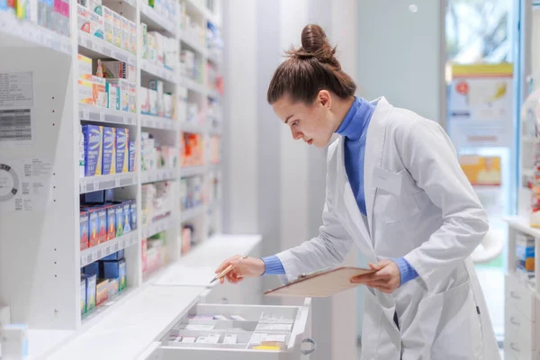 Jeune Pharmacien Vérifiant Stock Médicaments Dans Une Pharmacie — Photo