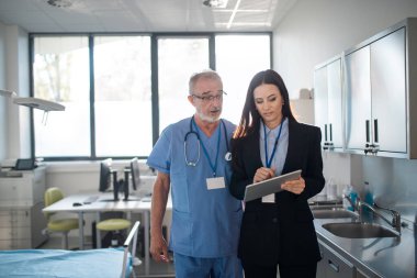 Genç eczacı hastanede doktora bir şey anlatıyor..