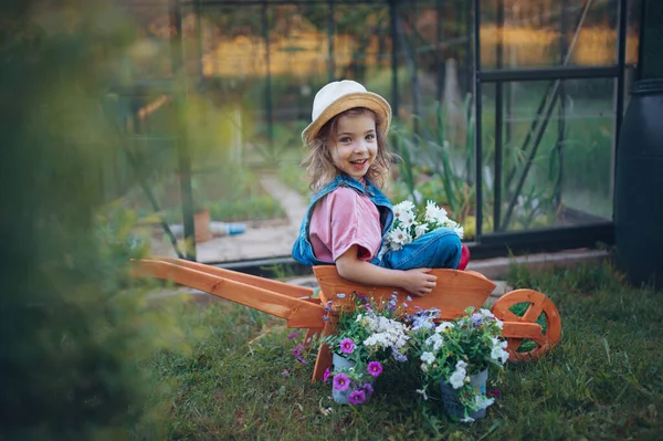 Menina Brincando Com Carrinho Mão Madeira Cheio Flores Jardim — Fotografia de Stock