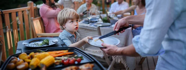 Father Putting Grilled Meat Vegetable Plate His Son Family Summer — Stock Photo, Image