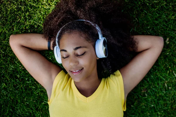Multiracial Girl Lying Grass Enjoying Music Headphones Top View — Zdjęcie stockowe